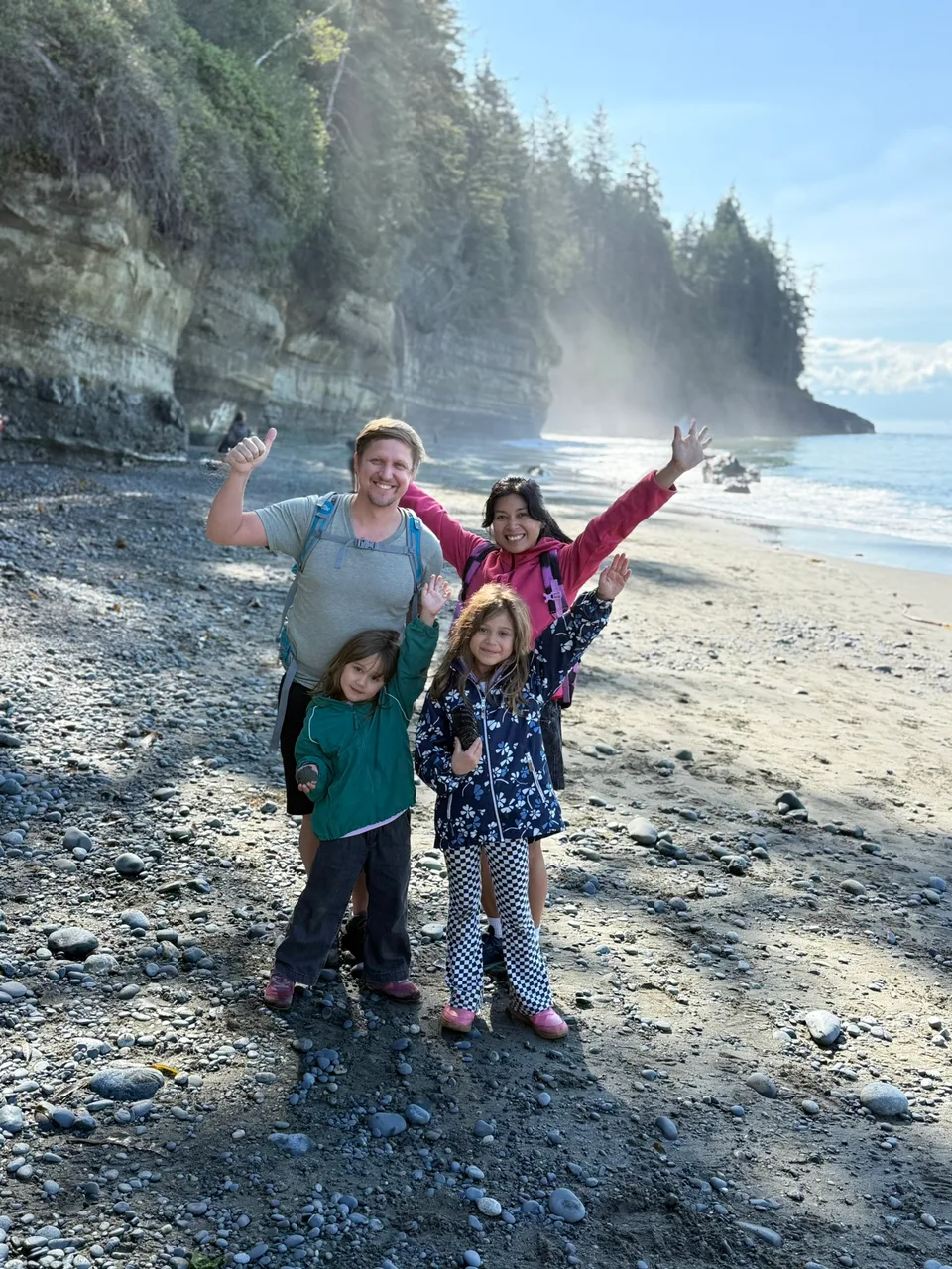 Unsere Familie gemeinsam an einem Strand mit bewaldeter Küste